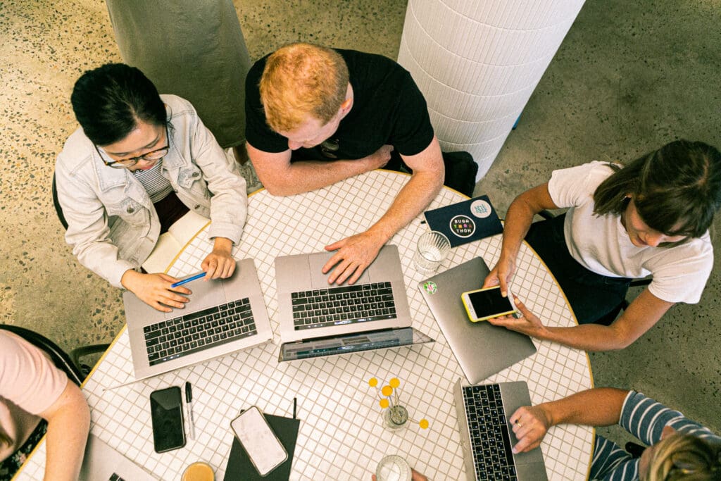 Four people having a digital services meeting discussing seo solutions and digital solutions