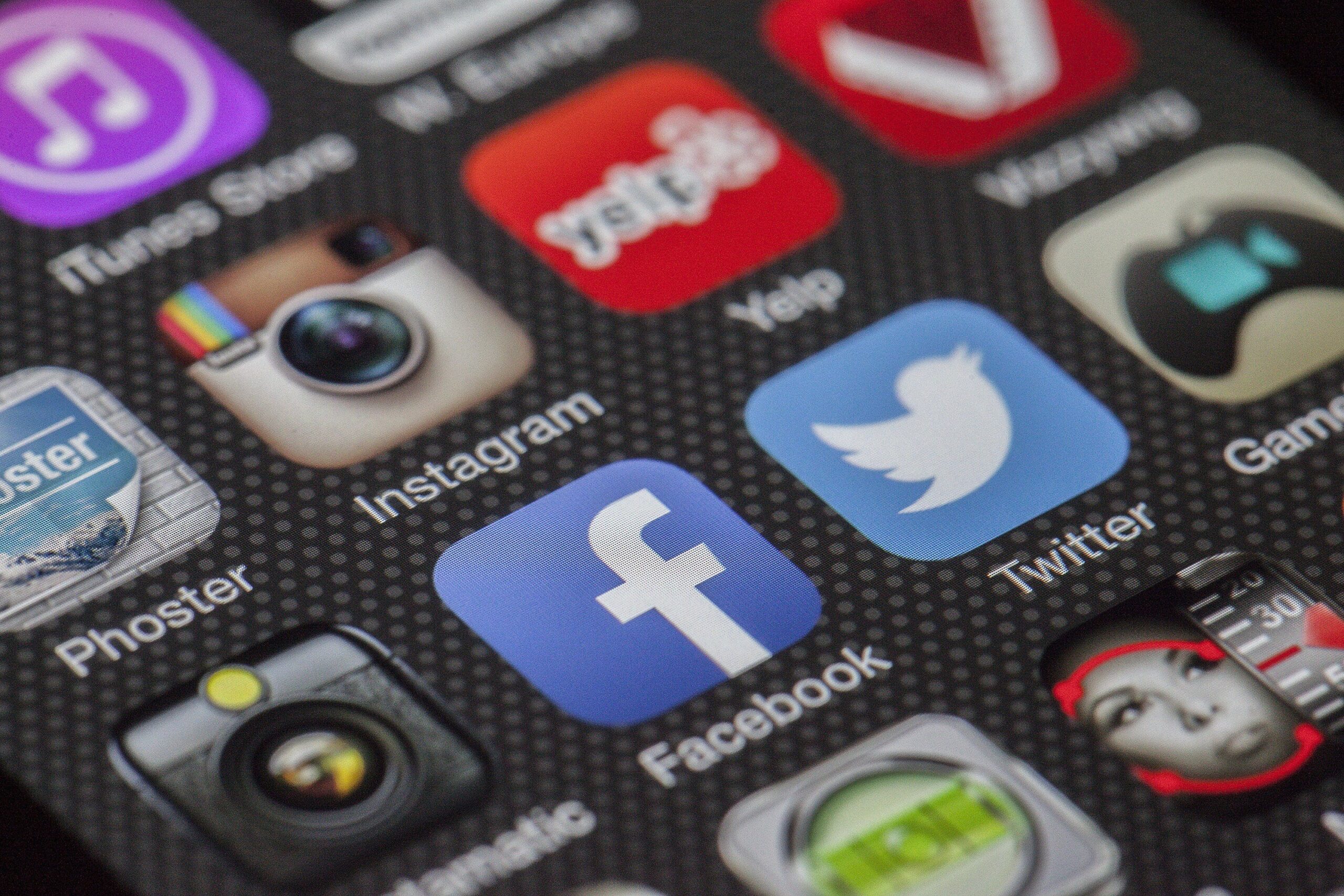 Close-up of a smartphone screen displaying various app icons like Instagram, Facebook, and Twitter, essential tools for small business marketing. The textured background adds depth to this social media showcase.