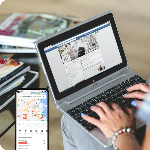 A person multitasks seamlessly, using a laptop displaying a Facebook page while their smartphone shows a map with nearby restaurant locations. Meanwhile, they incorporate SEO strategies to optimize online visibility, ensuring every digital touchpoint is effectively managed.