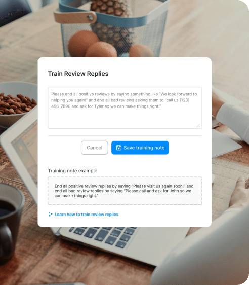 A laptop open on a table displays a dialog box for training review replies, seamlessly integrated with review management software. Options to save or cancel a training note are visible, as a person's hands rest on the keyboard.