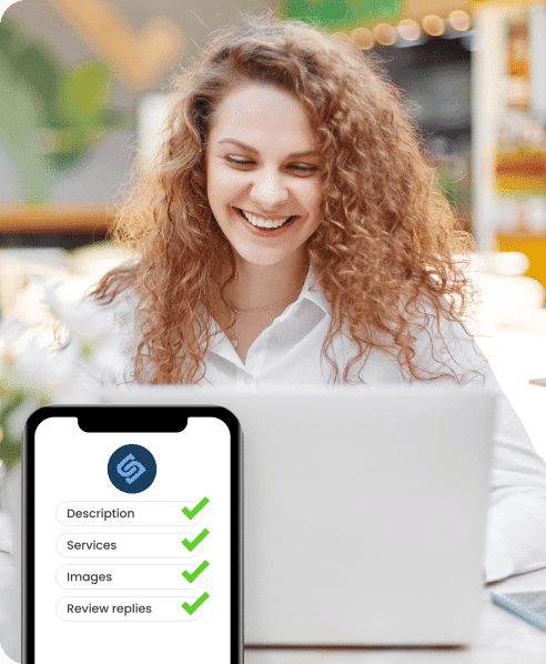 Smiling person with curly hair using a laptop. In the foreground, a smartphone screen shows checklist items: Description, Services, Images, Review replies, all checked.