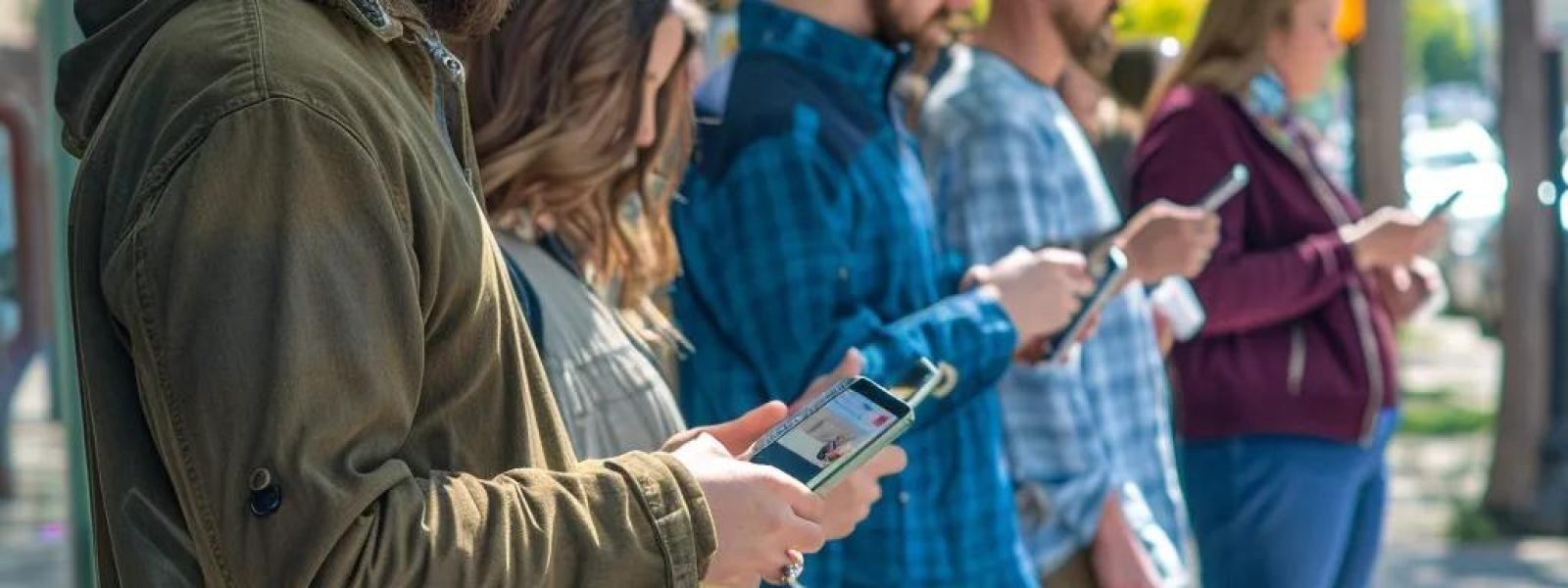 Group of people using smartphones outdoors, representing engagement with client reviews for local SEO strategies in Traverse City.